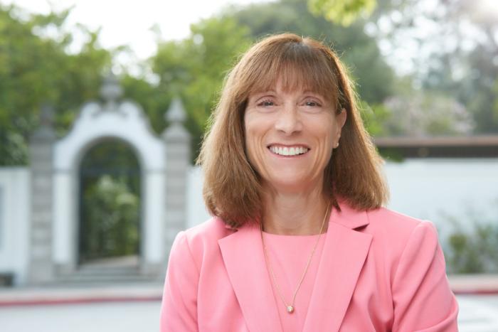Portrait of President Amy Marcus-Newhall in front of Honnold Gate at Scripps College